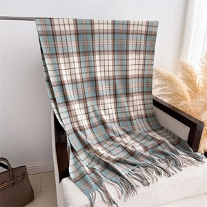 Close-up of classic blue and brown plaid scarf with fringe on a white armchair