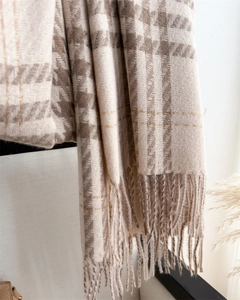 Detail of houndstooth scarf with golden thread accents and elegant fringe edges