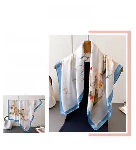 Dettaglio della stampa floreale a inchiostro e bordo azzurro su foulard in seta bianca
