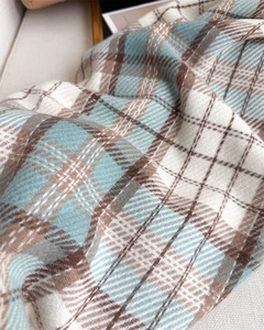 Close-up of soft blue and brown plaid scarf with high-density cashmere-like texture