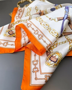 Detailed view of luxury satin scarf with equestrian gold chain and lilac ribbon patterns