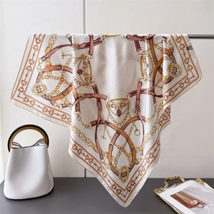 Elegant silk scarf with equestrian prints and buckle pattern draped in luxury setting