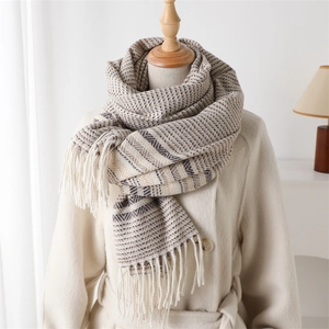 Detailed texture of thick herringbone cashmere-feel scarf with elegant fringe tassels