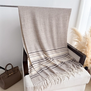 Detailed view of the soft knit texture and white tassel fringe on the striped scarf