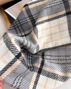 Close-up detail of soft classic brown and black plaid cashmere-like scarf with woven texture