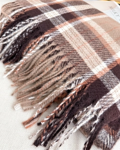 Macro shot of tassel details on classic brown plaid cashmere-like winter scarf