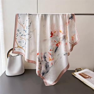 Dettaglio di un foulard in seta con elegante stampa floreale e bordi rosa rifiniti