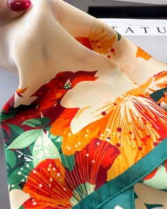Dettaglio del foulard in seta con stampa floreale e bordo verde dalla trama liscia