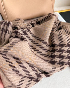 Macro detail of houndstooth scarf with gold metallic threads and soft cashmere feel