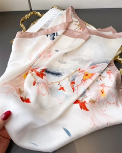 Dettaglio di elegante sciarpa di seta con fiori di magnolia e bordi rosa cipria