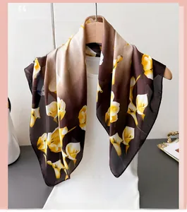Dettaglio foulard di seta floreale con calle gialle su tessuto marrone scuro