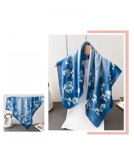 Dettaglio di un elegante foulard in seta blu con motivi floreali di calle bianche