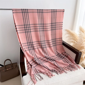 Detailed shot of pink plaid cashmere-feel scarf with elegant fringes on white chair