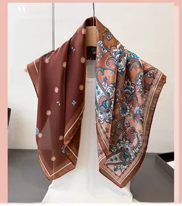 Detail of silk-like scarf with intricate brown paisley patterns and orange floral accents