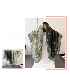 Detail of paisley and daisy print silk scarf showing dual-sided green pattern and texture
