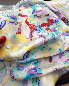 Dettaglio della consistenza liscia e della stampa astratta di un foulard di seta