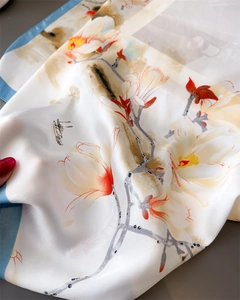 Dettaglio della trama in seta e della stampa di magnolia sul foulard elegante