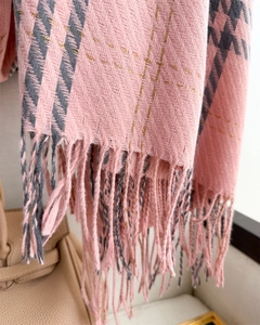 Detail of pink and gray plaid scarf with metallic gold threads and fringe tassels