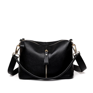 Minimalist black pebbled leather crossbody bag with gold hardware and vertical zippers
