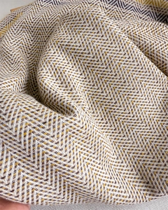 Close-up of zigzag patterned cashmere feel scarf with soft yellow and beige woven texture
