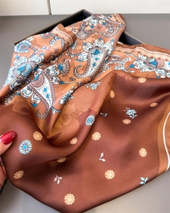 Detailed texture of brown paisley silk scarf with glossy satin finish and floral pattern