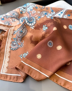 Close-up of paisley pattern silk scarf showing soft folds and detailed satin texture