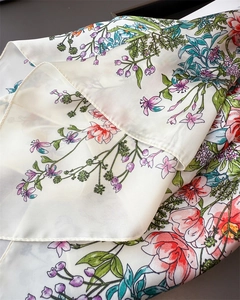 Dettaglio della stampa floreale su foulard in seta crema con motivi floreali vivaci