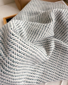 Close-up of luxury herringbone cashmere-feel scarf with soft fringe and premium texture
