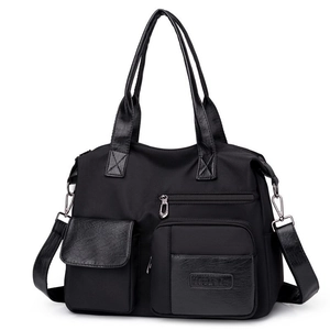 Classic black nylon tote bag with leather details, dual handles, and adjustable shoulder strap