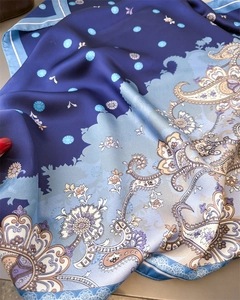 Detail of soft blue paisley silk scarf showing intricate texture and floral pattern