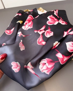 Dettaglio di elegante sciarpa di seta nera con grande stampa floreale di tulipani rosa