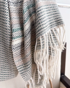 Detail of bohemian geometric knit pattern and long fringe on soft cashmere-like shawl