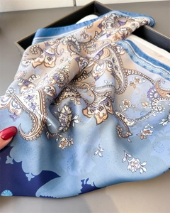 Detailed close-up showing the smooth silk texture and purple paisley print on a blue scarf