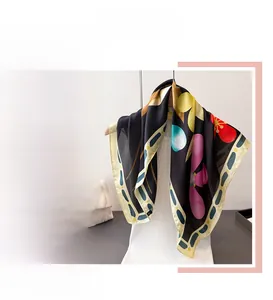 Détail d'un foulard en soie imprimé floral avec fleurs roses et jaunes sur fond noir