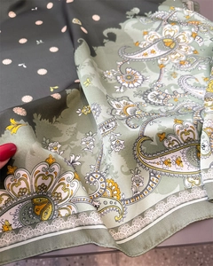 Close-up of paisley silk scarf showing smooth satin texture and floral lace edge