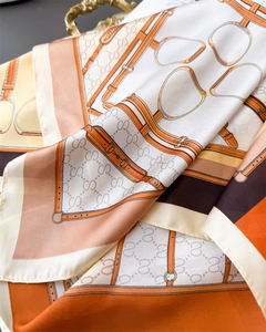 Detailed view of silk-satin scarf featuring equestrian buckle and S-monogram pattern