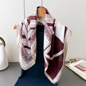 Retro geometric print silk scarf in burgundy and beige on a wooden hanger display