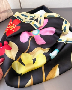 Détail macro d'un foulard en satin aux imprimés floraux vifs et texture soyeuse