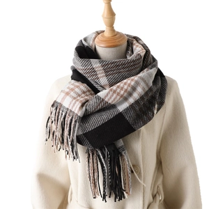Classic plaid long scarf with tassels in black and brown, styled on a beige coat