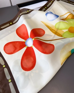 Détail d'un foulard en soie à imprimé floral, fleurs rouges et texture satinée lisse