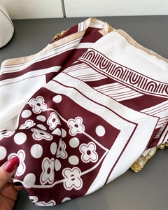 Detail of burgundy floral silk scarf featuring geometric patterns and satin finish