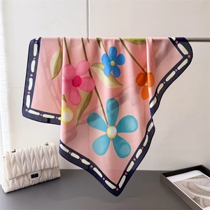 Détail du foulard en satin aux fleurs roses et bleues avec bordure foncée élégante