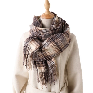 Écharpe à carreaux et franges marron et beige présentée sur un mannequin de mode