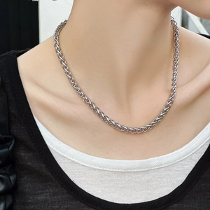 Collier maille épi en acier inoxydable argenté porté sur des vêtements superposés