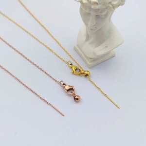 Detail view of gold and rose gold stainless steel needle chain with lobster clasp and bead