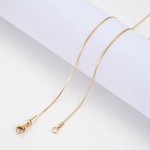 Close-up of golden stainless steel S-chain necklace with high-quality lobster clasp detail