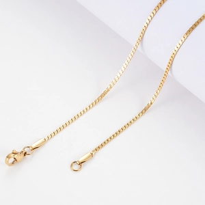 Gros plan d'un collier chaîne serpent plate dorée avec fermoir mousqueton robuste