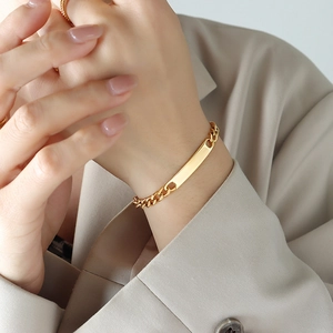 Detailed view of a gold-plated stainless steel Cuban link bracelet on a wrist
