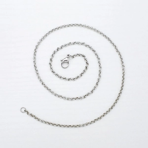 Gros plan d'une chaîne à billes en acier inoxydable en spirale sur fond blanc