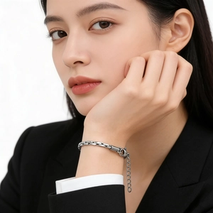 Sleek silver stainless steel chain bracelet with lobster clasp worn with business suit